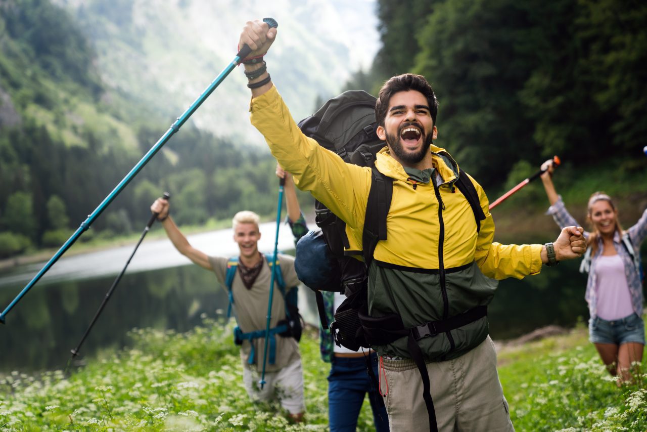 group-of-smiling-friends-hiking-with-backpacks-outdoors-travel-tourism-hike-and-people-concept